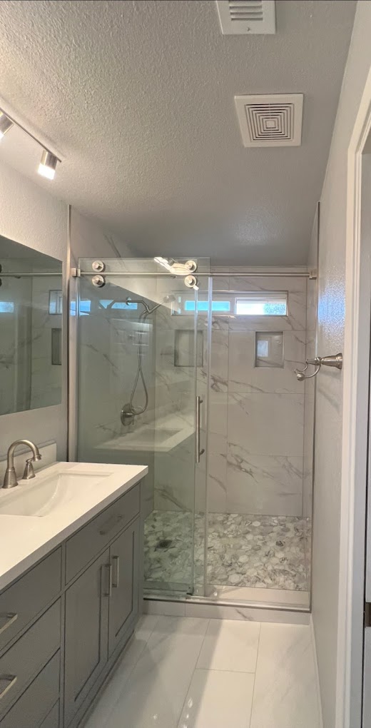 Marble tile walk-in shower with pebble floor - bathroom renovation Riverside